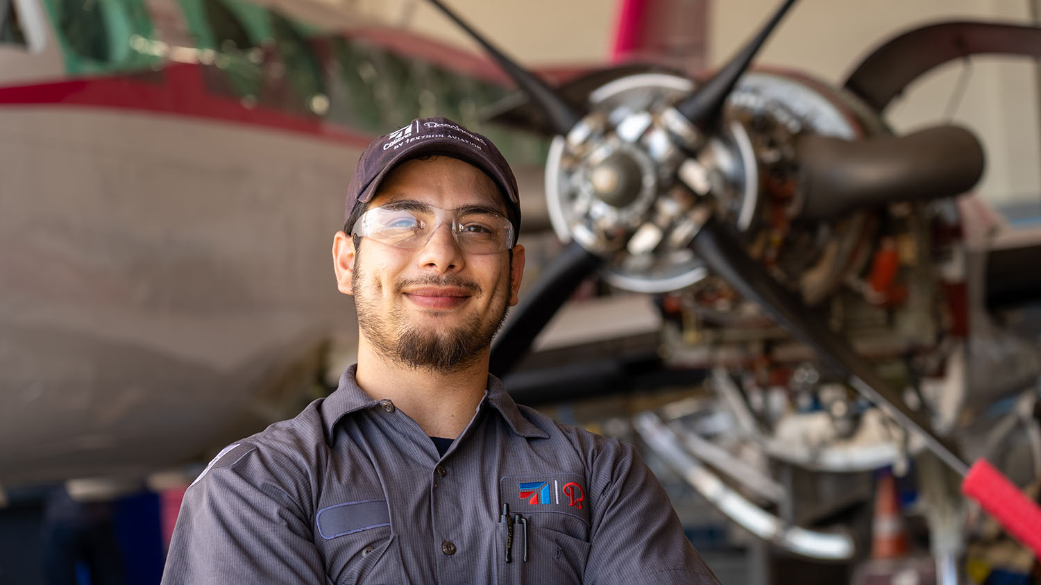 A&P mechanic in front of turboprop aircraft powerplant.