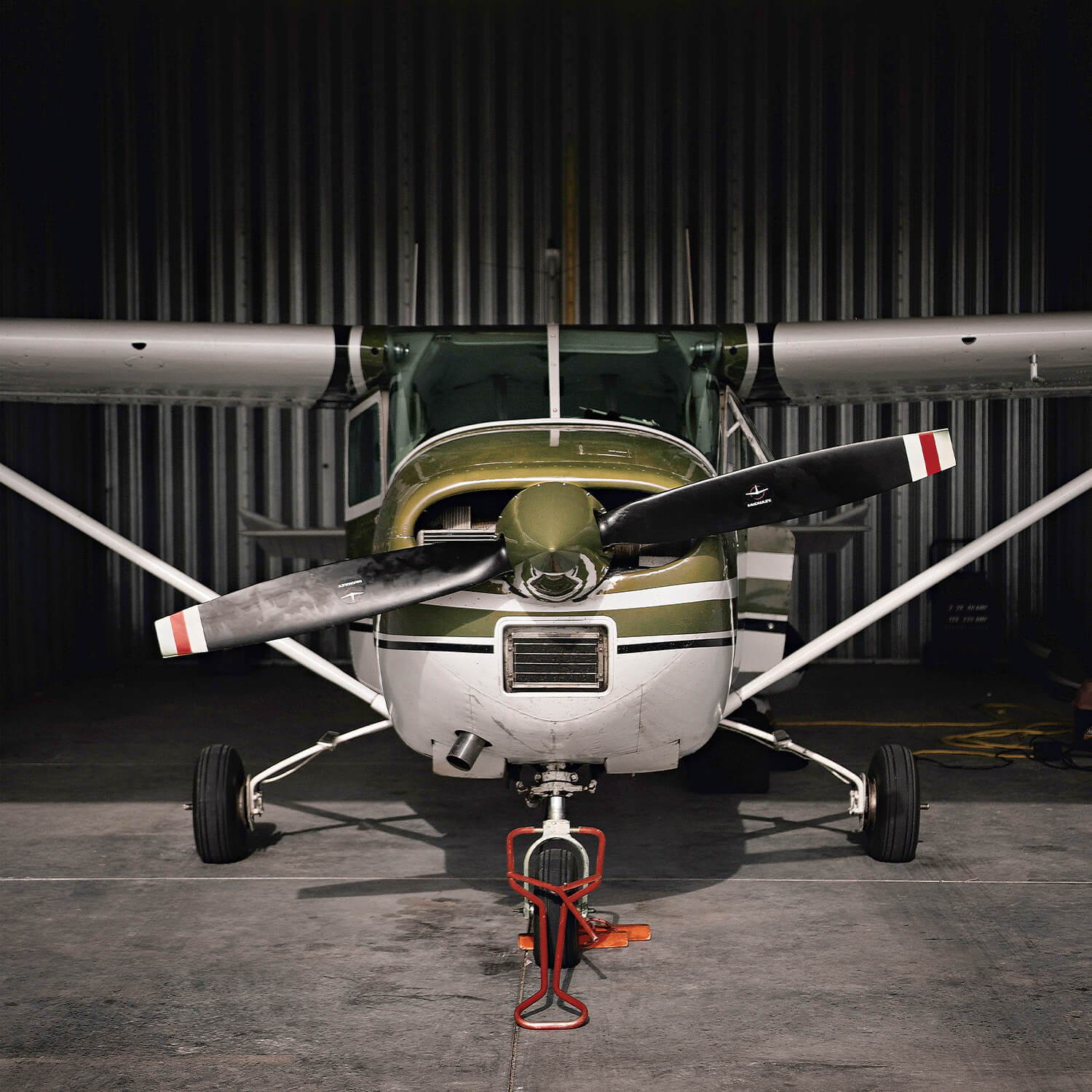 Cessna piston straight on in hangar.