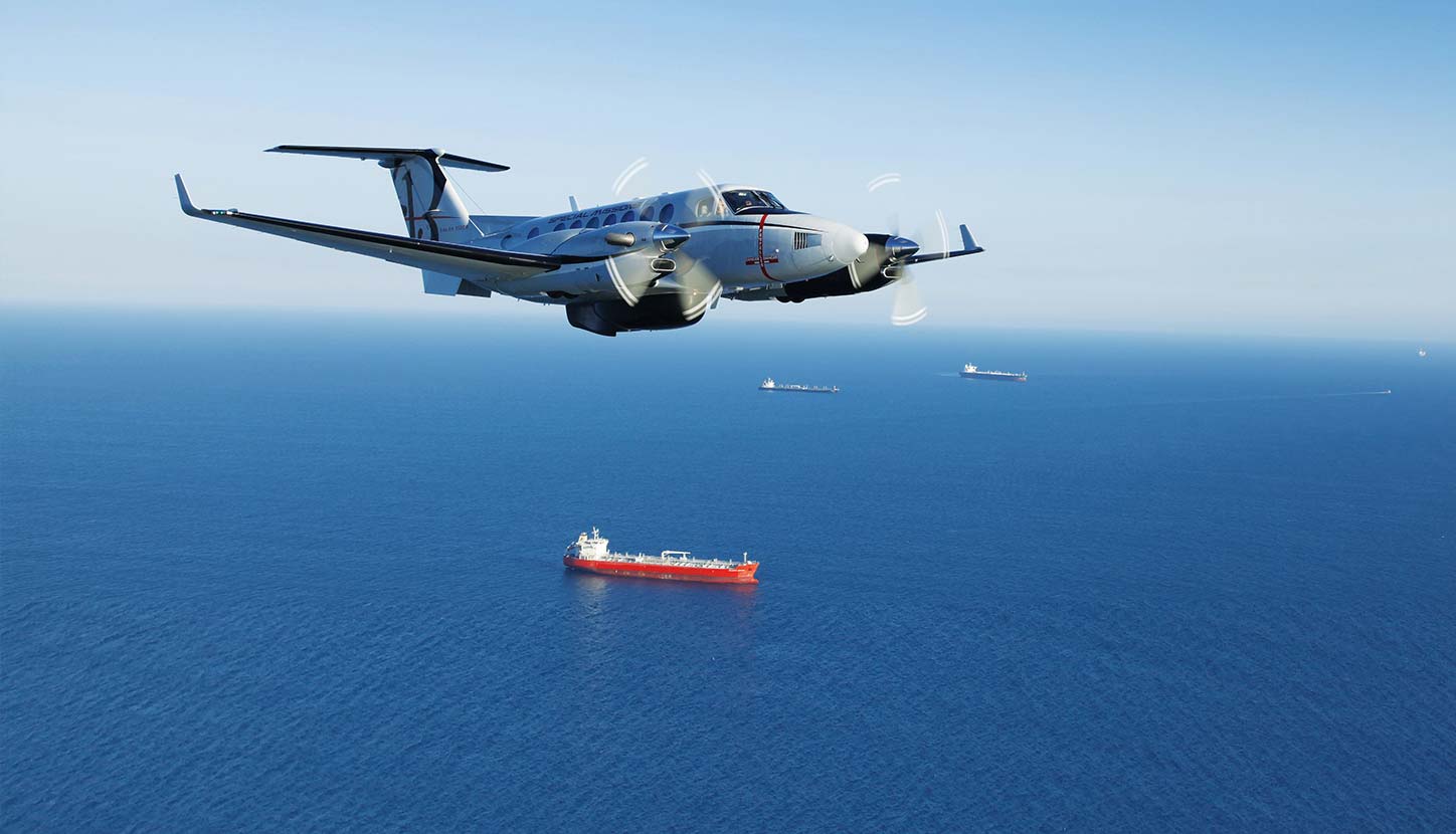 An airborne King Air 360 twin turboprop conducts a surveillance mission over water